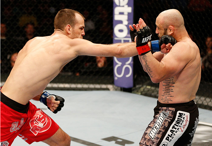 BOSTON, MA - AUGUST 17:  (L-R) Cole Miller punches Manny Gamburyan in their UFC featherweight bout at TD Garden on August 17, 2013 in Boston, Massachusetts. (Photo by Josh Hedges/Zuffa LLC/Zuffa LLC via Getty Images)