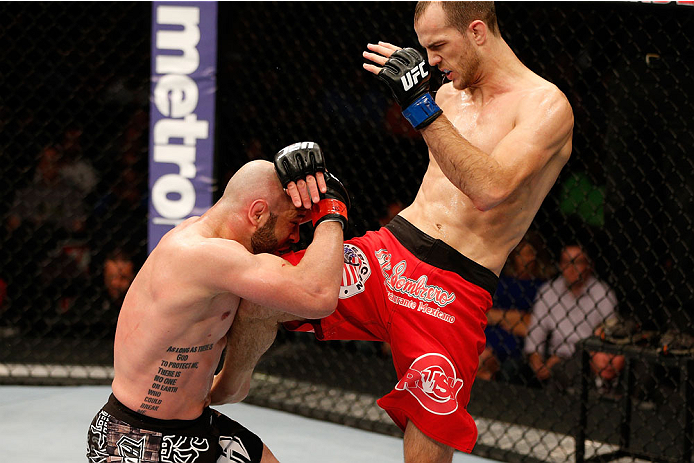 BOSTON, MA - AUGUST 17:  (R-L) Cole Miller knees Manny Gamburyan in their UFC featherweight bout at TD Garden on August 17, 2013 in Boston, Massachusetts. (Photo by Josh Hedges/Zuffa LLC/Zuffa LLC via Getty Images)