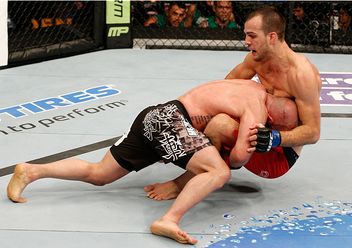 BOSTON, MA - AUGUST 17:  (L-R) Manny Gamburyan takes down Cole Miller in their UFC featherweight bout at TD Garden on August 17, 2013 in Boston, Massachusetts. (Photo by Josh Hedges/Zuffa LLC/Zuffa LLC via Getty Images)