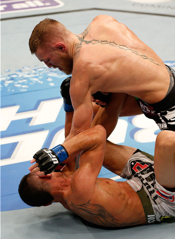 BOSTON, MA - AUGUST 17:  (R-L) Conor McGregor punches Max Holloway in their UFC featherweight bout at TD Garden on August 17, 2013 in Boston, Massachusetts. (Photo by Josh Hedges/Zuffa LLC/Zuffa LLC via Getty Images)