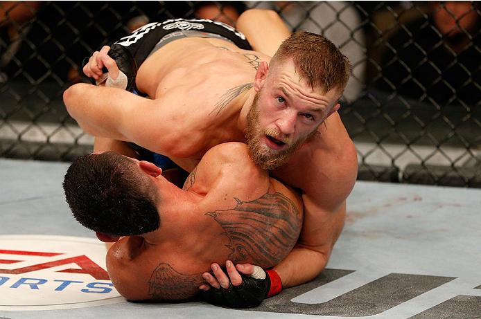 BOSTON, MA - AUGUST 17:  Conor McGregor (top) looks at the clock as he battles Max Holloway in their UFC featherweight bout at TD Garden on August 17, 2013 in Boston, Massachusetts. (Photo by Josh Hedges/Zuffa LLC/Zuffa LLC via Getty Images)