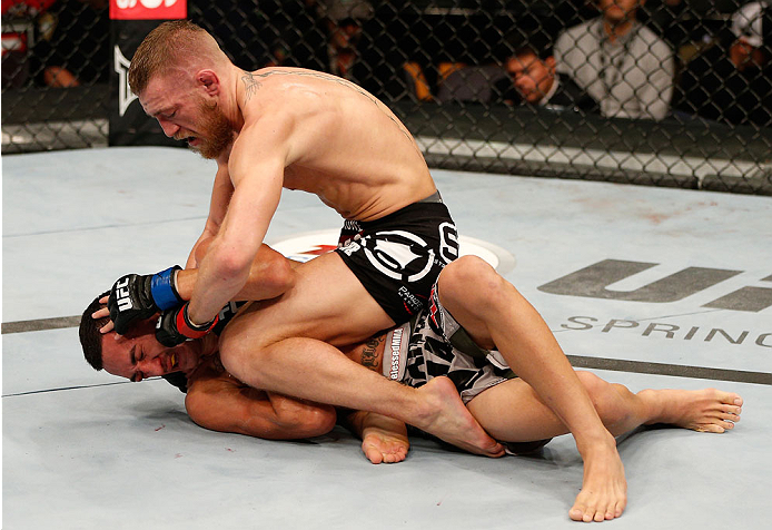 BOSTON, MA - AUGUST 17:  (R-L) Conor McGregor punches Max Holloway in their UFC featherweight bout at TD Garden on August 17, 2013 in Boston, Massachusetts. (Photo by Josh Hedges/Zuffa LLC/Zuffa LLC via Getty Images)