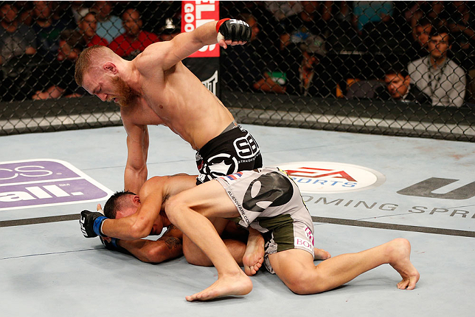 BOSTON, MA - AUGUST 17:  (R-L) Conor McGregor punches Max Holloway in their UFC featherweight bout at TD Garden on August 17, 2013 in Boston, Massachusetts. (Photo by Josh Hedges/Zuffa LLC/Zuffa LLC via Getty Images)