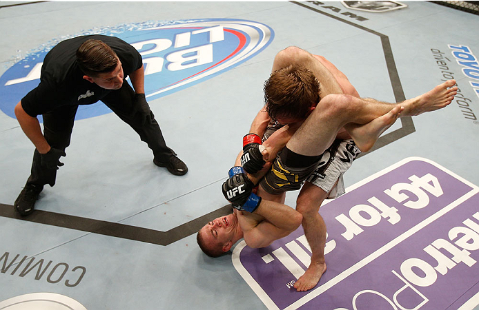 BOSTON, MA - AUGUST 17:  Michael McDonald (bottom) secures a triangle choke submission against Brad Pickett in their UFC bantamweight bout at TD Garden on August 17, 2013 in Boston, Massachusetts. (Photo by Josh Hedges/Zuffa LLC/Zuffa LLC via Getty Images