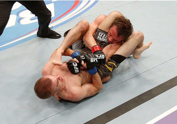 BOSTON, MA - AUGUST 17:  Michael McDonald (bottom) secures a triangle choke submission against Brad Pickett in their UFC bantamweight bout at TD Garden on August 17, 2013 in Boston, Massachusetts. (Photo by Josh Hedges/Zuffa LLC/Zuffa LLC via Getty Images