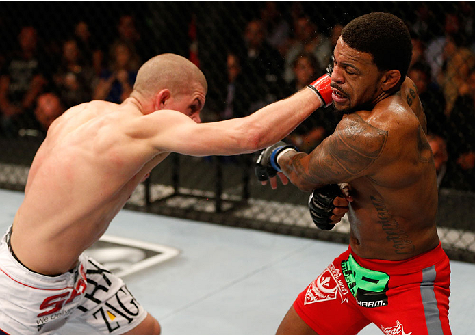 BOSTON, MA - AUGUST 17:  (L-R) Joe Lauzon punches Michael Johnson in their UFC lightweight bout at TD Garden on August 17, 2013 in Boston, Massachusetts. (Photo by Josh Hedges/Zuffa LLC/Zuffa LLC via Getty Images)