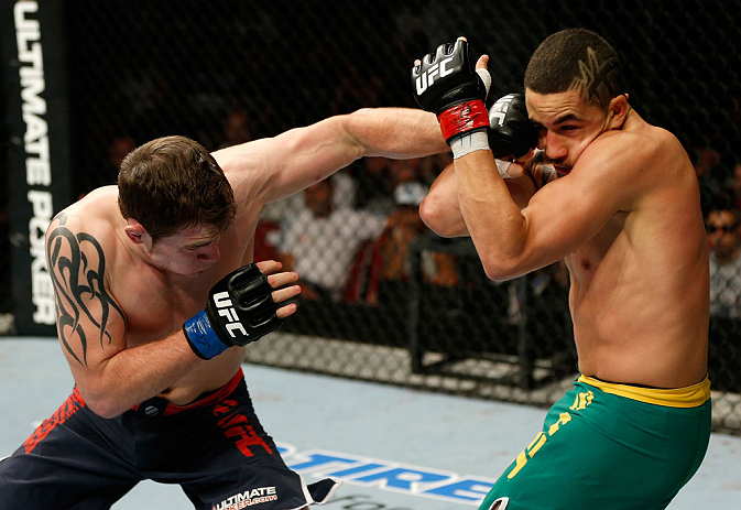 GOLD COAST, AUSTRALIA - DECEMBER 15:  (L-R) Bradley Scott punches Robert Whittaker during their welterweight fight at the UFC on FX event on December 15, 2012  at Gold Coast Convention and Exhibition Centre in Gold Coast, Australia.  (Photo by Josh Hedges