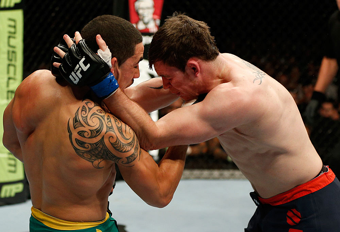 GOLD COAST, AUSTRALIA - DECEMBER 15:  (L-R) Robert Whittaker punches Bradley Scott during their welterweight fight at the UFC on FX event on December 15, 2012  at Gold Coast Convention and Exhibition Centre in Gold Coast, Australia.  (Photo by Josh Hedges