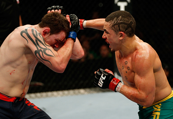 GOLD COAST, AUSTRALIA - DECEMBER 15:  (R-L) Robert Whittaker punches Bradley Scott during their welterweight fight at the UFC on FX event on December 15, 2012  at Gold Coast Convention and Exhibition Centre in Gold Coast, Australia.  (Photo by Josh Hedges