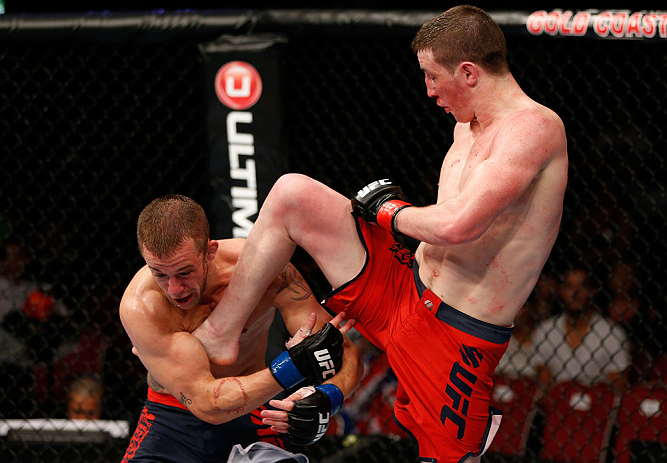 GOLD COAST, AUSTRALIA - DECEMBER 15:  (R-L) Brendan Loughnane delivers a flying knee against Mike Wilkinson during their lightweight fight at the UFC on FX event on December 15, 2012  at Gold Coast Convention and Exhibition Centre in Gold Coast, Australia
