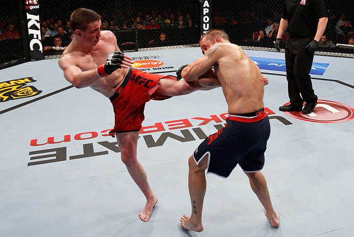 GOLD COAST, AUSTRALIA - DECEMBER 15:  (L-R) Brendan Loughnane kicks Mike Wilkinson during their lightweight fight at the UFC on FX event on December 15, 2012  at Gold Coast Convention and Exhibition Centre in Gold Coast, Australia.  (Photo by Josh Hedges/