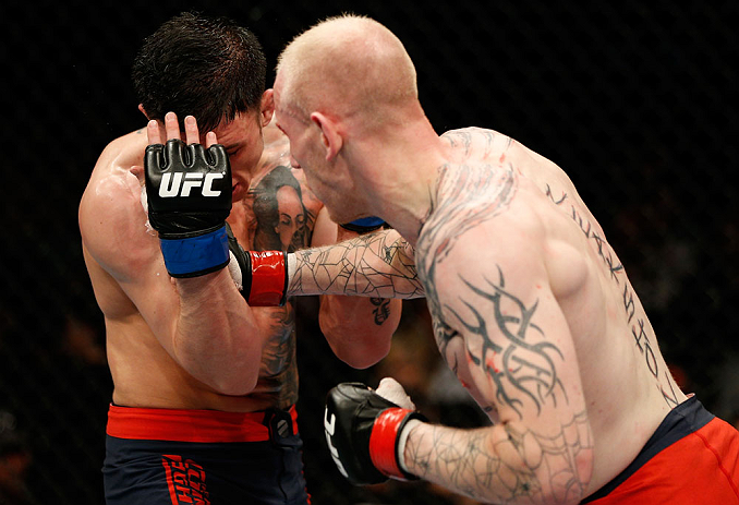 GOLD COAST, AUSTRALIA - DECEMBER 15:  (R-L) Colin Fletcher punches Norman Parke during their lightweight fight at the UFC on FX event on December 15, 2012  at Gold Coast Convention and Exhibition Centre in Gold Coast, Australia.  (Photo by Josh Hedges/Zuf