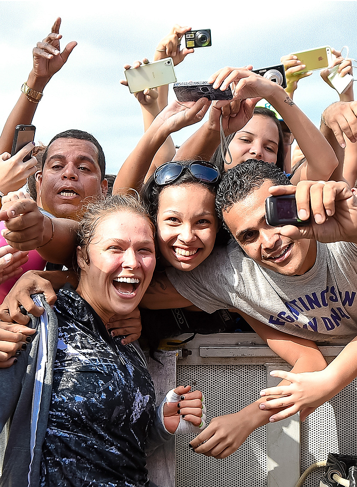 RIO DE JANEIRO, BRAZIL - JULY 29: Womens bantamweight champion Ronda Rousey of the United States takes photos with fans during open training session at Pepe Beach on July 29, 2015 in Rio de Janeiro, Brazil. (Photo by Buda Mendes/Zuffa LLC/Zuffa LLC via