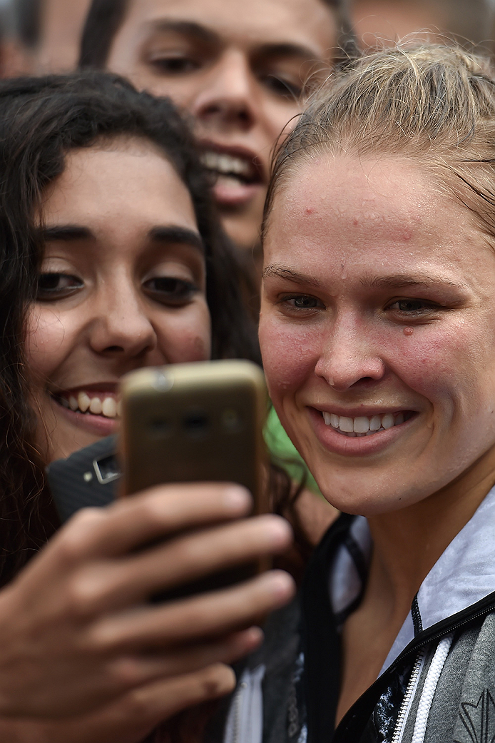RIO DE JANEIRO, BRAZIL - JULY 29: Womens bantamweight champion Ronda Rousey of the United States takes photos with fans during open training session at Pepe Beach on July 29, 2015 in Rio de Janeiro, Brazil. (Photo by Buda Mendes/Zuffa LLC/Zuffa LLC via