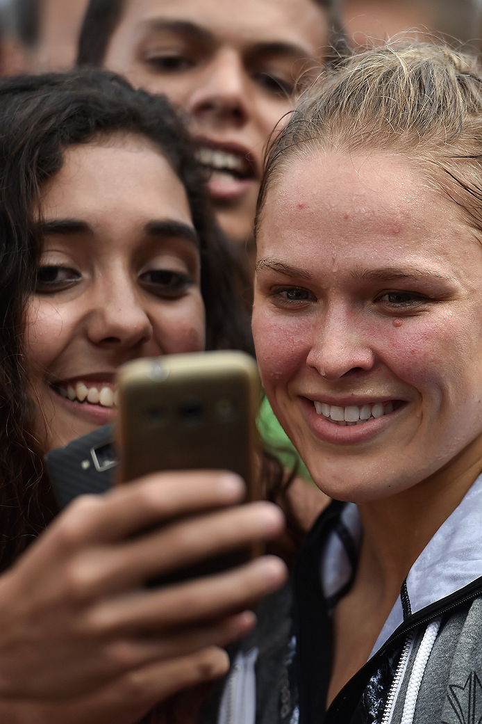 RIO DE JANEIRO, BRAZIL - JULY 29:  Womens bantamweight champion Ronda Rousey of the United States takes photos with fans during open training session at Pepe Beach on July 29, 2015 in Rio de Janeiro, Brazil.  (Photo by Buda Mendes/Zuffa LLC/Zuffa LLC via 