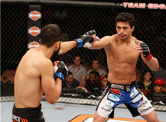 LAS VEGAS, NV - JULY 06:  (R-L) Adriano Martins exchanges punches with Juan Maneul Puig Carreon in their lightweight fight during the Ultimate Fighter Finale inside the Mandalay Bay Events Center on July 6, 2014 in Las Vegas, Nevada.  (Photo by Josh Hedge