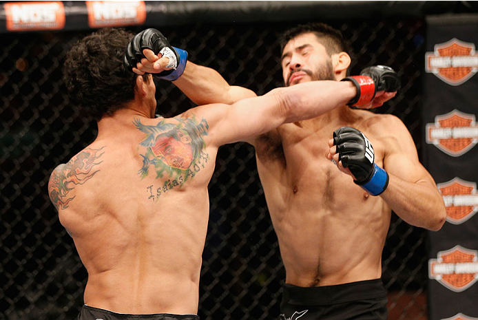 LAS VEGAS, NV - JULY 06:  (L-R) Adriano Martins exchanges punches with Juan Maneul Puig Carreon in their lightweight fight during the Ultimate Fighter Finale inside the Mandalay Bay Events Center on July 6, 2014 in Las Vegas, Nevada.  (Photo by Josh Hedge