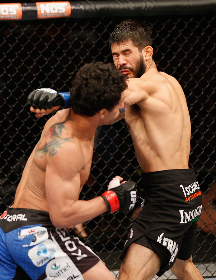 LAS VEGAS, NV - JULY 06:  (L-R) Adriano Martins punches Juan Maneul Puig Carreon in their lightweight fight during the Ultimate Fighter Finale inside the Mandalay Bay Events Center on July 6, 2014 in Las Vegas, Nevada.  (Photo by Josh Hedges/Zuffa LLC/Zuf