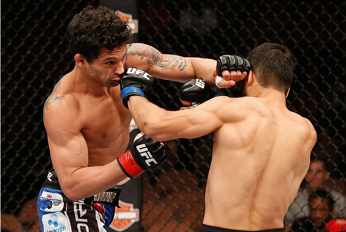 LAS VEGAS, NV - JULY 06:  (L-R) Adriano Martins exchanges punches with Juan Maneul Puig Carreon in their lightweight fight during the Ultimate Fighter Finale inside the Mandalay Bay Events Center on July 6, 2014 in Las Vegas, Nevada.  (Photo by Josh Hedge