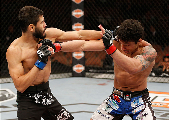 LAS VEGAS, NV - JULY 06:  (L-R) Juan Maneul Puig Carreon exchanges punches with Adriano Martins in their lightweight fight during the Ultimate Fighter Finale inside the Mandalay Bay Events Center on July 6, 2014 in Las Vegas, Nevada.  (Photo by Josh Hedge