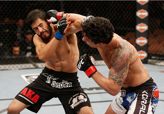 LAS VEGAS, NV - JULY 06:  (L-R) Juan Maneul Puig Carreon exchanges punches with Adriano Martins in their lightweight fight during the Ultimate Fighter Finale inside the Mandalay Bay Events Center on July 6, 2014 in Las Vegas, Nevada.  (Photo by Josh Hedge