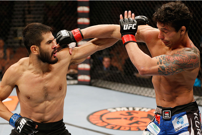 LAS VEGAS, NV - JULY 06: (L-R) Juan Maneul Puig Carreon punches with Adriano Martins in their lightweight fight during the Ultimate Fighter Finale inside the Mandalay Bay Events Center on July 6, 2014 in Las Vegas, Nevada. (Photo by Josh Hedges/Zuffa LL
