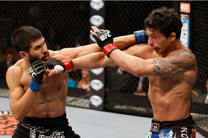 LAS VEGAS, NV - JULY 06:  (L-R) Juan Maneul Puig Carreon exchanges punches with Adriano Martins in their lightweight fight during the Ultimate Fighter Finale inside the Mandalay Bay Events Center on July 6, 2014 in Las Vegas, Nevada.  (Photo by Josh Hedge