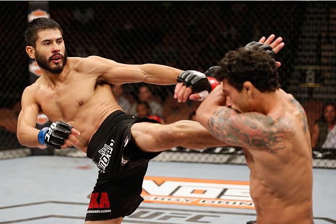 LAS VEGAS, NV - JULY 06:  (L-R) Juan Maneul Puig Carreon kicks Adriano Martins in their lightweight fight during the Ultimate Fighter Finale inside the Mandalay Bay Events Center on July 6, 2014 in Las Vegas, Nevada.  (Photo by Josh Hedges/Zuffa LLC/Zuffa