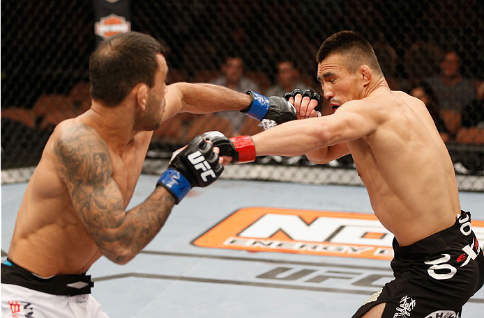 LAS VEGAS, NV - JULY 06:  (L-R) Leandro Issa punches Jumabieke Tuerxun in their bantamweight fight during the Ultimate Fighter Finale inside the Mandalay Bay Events Center on July 6, 2014 in Las Vegas, Nevada.  (Photo by Josh Hedges/Zuffa LLC/Zuffa LLC vi