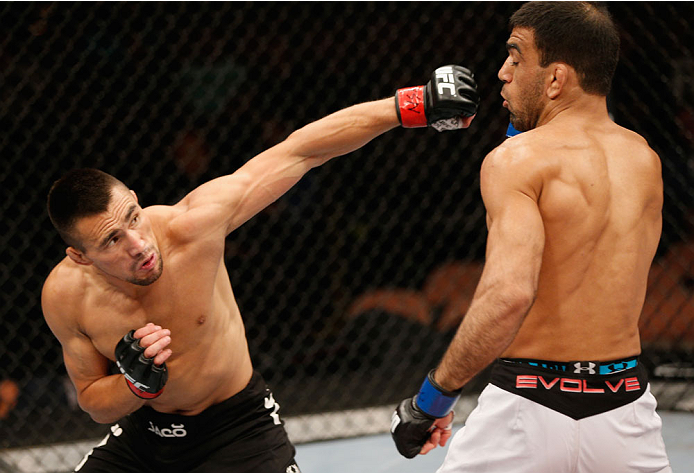 LAS VEGAS, NV - JULY 06:  (L-R) Jumabieke Tuerxun punches Leandro Issa in their bantamweight fight during the Ultimate Fighter Finale inside the Mandalay Bay Events Center on July 6, 2014 in Las Vegas, Nevada.  (Photo by Josh Hedges/Zuffa LLC/Zuffa LLC vi