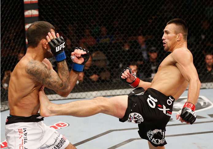 LAS VEGAS, NV - JULY 06: (R-L) Jumabieke Tuerxun kicks Leandro Issa in their bantamweight fight during the Ultimate Fighter Finale inside the Mandalay Bay Events Center on July 6, 2014 in Las Vegas, Nevada. (Photo by Josh Hedges/Zuffa LLC/Zuffa LLC via