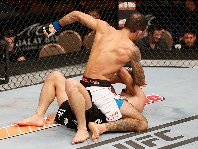LAS VEGAS, NV - JULY 06: (top) Leandro Issa punches Jumabieke Tuerxun in their bantamweight fight during the Ultimate Fighter Finale inside the Mandalay Bay Events Center on July 6, 2014 in Las Vegas, Nevada. (Photo by Josh Hedges/Zuffa LLC/Zuffa LLC vi