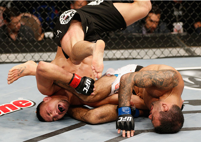 LAS VEGAS, NV - JULY 06: (R-L) Leandro Issa submits Jumabieke via armbar in their bantamweight fight during the Ultimate Fighter Finale inside the Mandalay Bay Events Center on July 6, 2014 in Las Vegas, Nevada. (Photo by Josh Hedges/Zuffa LLC/Zuffa LLC