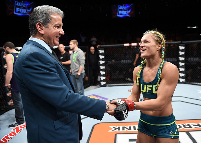 LAS VEGAS, NEVADA - DECEMBER 12: (R-L) Felice Herrig hakes hands with ring announcer Bruce Buffer after her submission victory over Lisa Ellis in their strawweight fight during The Ultimate Fighter Finale event inside the Pearl concert theater at the Pal