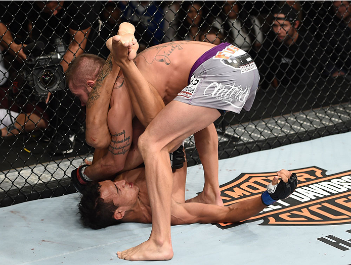 LAS VEGAS, NEVADA - DECEMBER 12: (R-L) Jeremy Stephens slams Charles Oliveira in their lightweight fight during The Ultimate Fighter Finale event inside the Pearl concert theater at the Palms Casino Resort on December 12, 2014 in Las Vegas, Nevada. (Phot