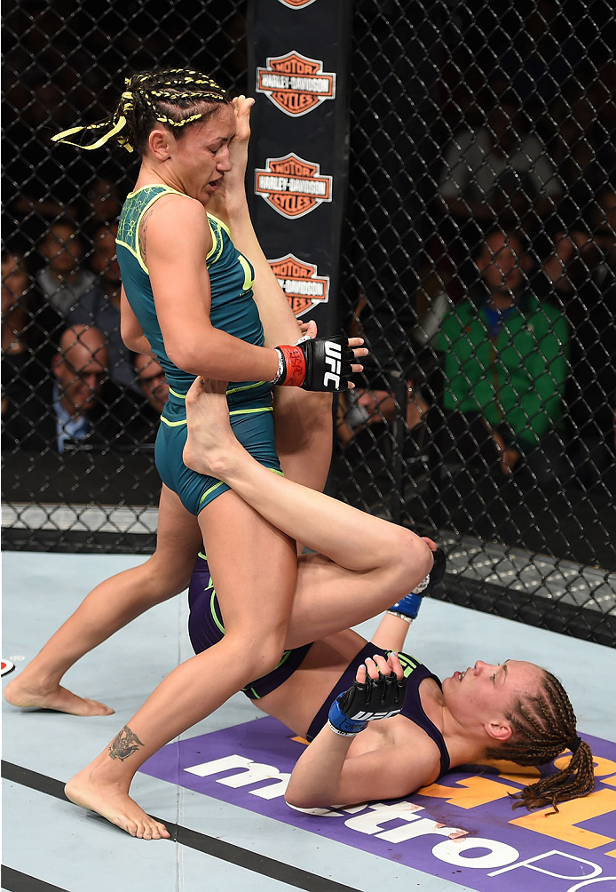 LAS VEGAS, NEVADA - DECEMBER 12: Carla Esparza (top) takes an up-kick from Rose Namajunas in their strawweight championship fight during The Ultimate Fighter Finale event inside the Pearl concert theater at the Palms Casino Resort on December 12, 2014 in
