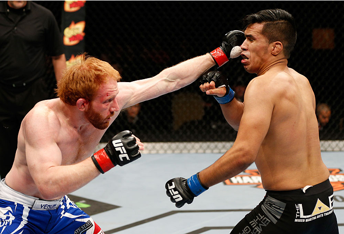 QUEBEC CITY, CANADA - APRIL 16:  (L-R) Mark Bocek punches Mike de la Torre in their lightweight fight during the TUF Nations Finale at Colisee Pepsi on April 16, 2014 in Quebec City, Quebec, Canada. (Photo by Josh Hedges/Zuffa LLC/Zuffa LLC via Getty Imag