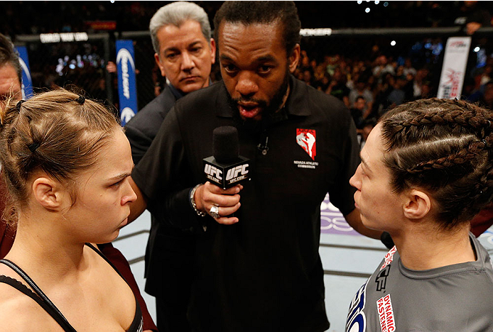 LAS VEGAS, NV - FEBRUARY 22:  Ronda Rousey (left) and Sara McMann (right) listen to instructions from referee Herb Dean (center) before their women's bantamweight championship bout during UFC 170 inside the Mandalay Bay Events Center on February 22, 2014 