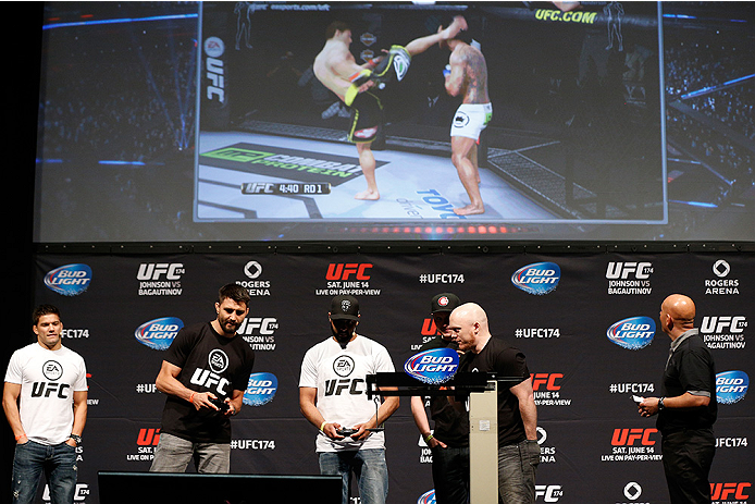 VANCOUVER, BC - JUNE 13:  Carlos Condit battles against a fan during a demo of the new EA Sports UFC videogame before the UFC 174 weigh-in at Rogers Arena on June 13, 2014 in Vancouver, Canada.  (Photo by Josh Hedges/Zuffa LLC/Zuffa LLC via Getty Images)