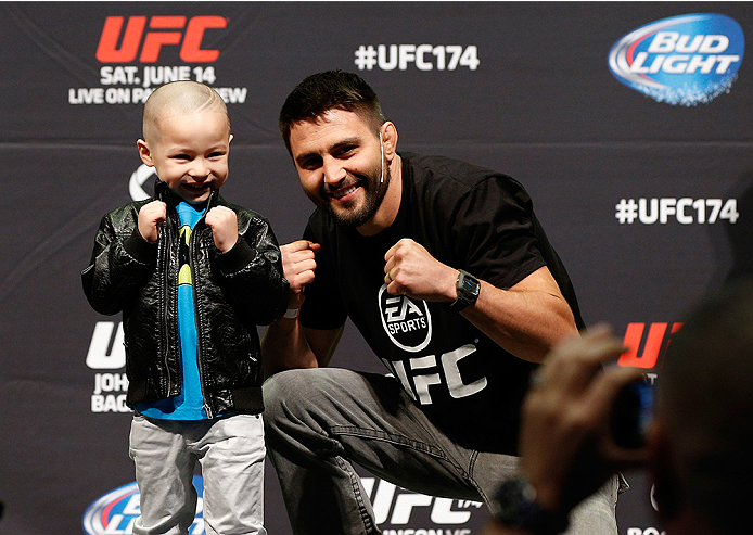 VANCOUVER, BC - JUNE 13:  Carlos Condit poses for photos with young fans after a Q&A session before the UFC 174 weigh-in at Rogers Arena on June 13, 2014 in Vancouver, Canada.  (Photo by Josh Hedges/Zuffa LLC/Zuffa LLC via Getty Images)