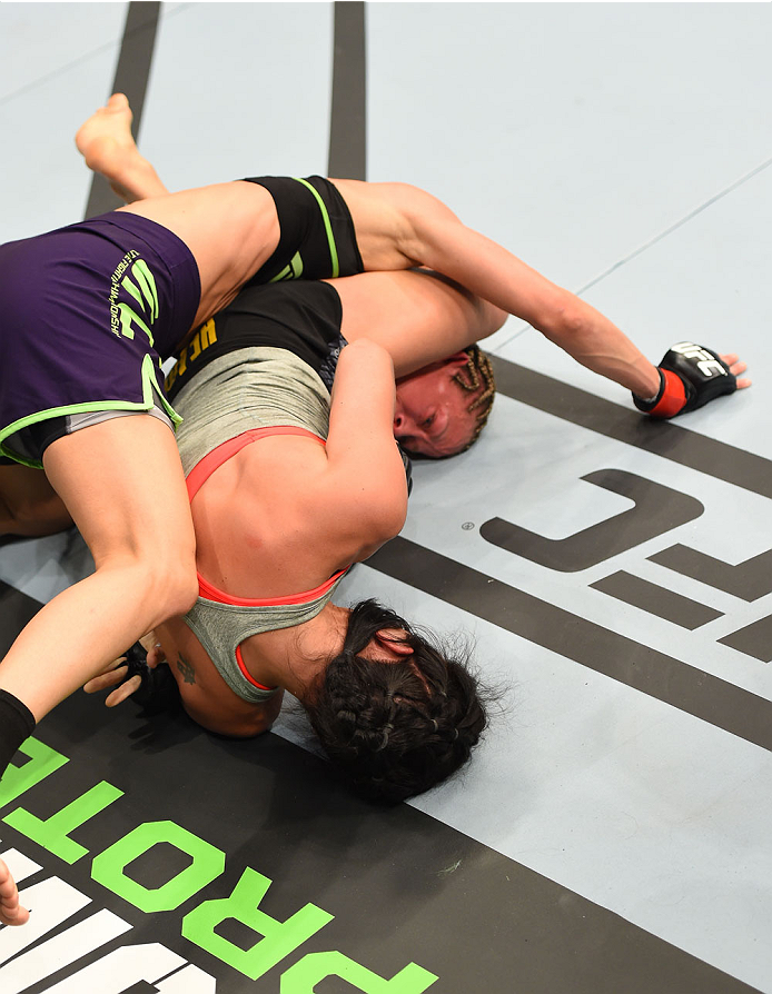 MONTREAL, QC - APRIL 25:   (R-L) Valerie Letourneau of Canada attempts to secure a triangle choke submission against Jessica Rakoczy in their women's strawweight bout during the UFC 186 event at the Bell Centre on April 25, 2015 in Montreal, Quebec, Canad