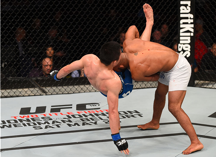 MONTREAL, QC - APRIL 25: (R-L) Demetrious Johnson of the United States takes down Kyoji Horiguchi of Japan in their UFC flyweight championship bout during the UFC 186 event at the Bell Centre on April 25, 2015 in Montreal, Quebec, Canada. (Photo by Josh
