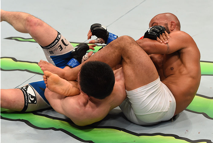 MONTREAL, QC - APRIL 25: (R-L) Demetrious Johnson of the United States secures an arm bar submission against Kyoji Horiguchi in their UFC flyweight championship bout during the UFC 186 event at the Bell Centre on April 25, 2015 in Montreal, Quebec, Cana