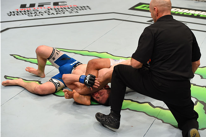 MONTREAL, QC - APRIL 25: Kyoji Horiguchi of Japan taps to an arm bar submission by Demetrious Johnson of the United States in their UFC flyweight championship bout during the UFC 186 event at the Bell Centre on April 25, 2015 in Montreal, Quebec, Canada