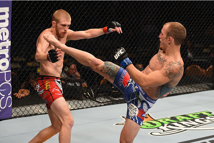 LAS VEGAS, NV - MAY 23: (R-L) Joshua Sampo kicks Justin Scoggins in their flyweight bout during the UFC 187 event at the MGM Grand Garden Arena on May 23, 2015 in Las Vegas, Nevada. (Photo by Josh Hedges/Zuffa LLC/Zuffa LLC via Getty Images)