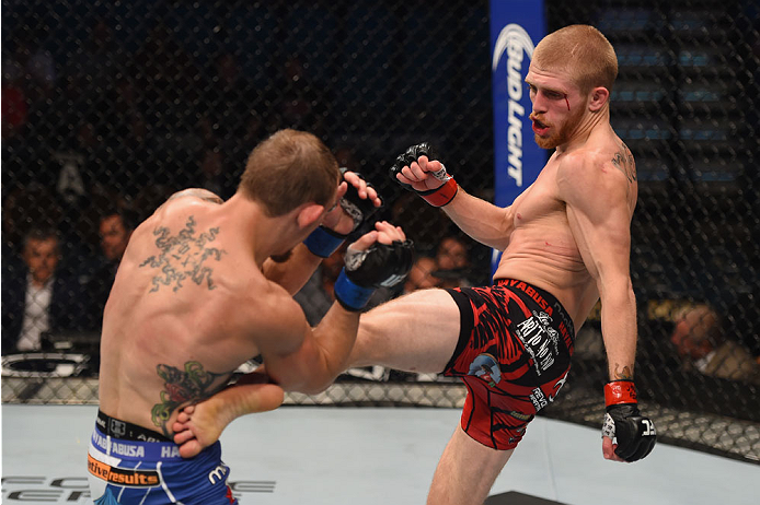 LAS VEGAS, NV - MAY 23: (R-L) Justin Scoggins kicks Joshua Sampo in their flyweight bout during the UFC 187 event at the MGM Grand Garden Arena on May 23, 2015 in Las Vegas, Nevada. (Photo by Josh Hedges/Zuffa LLC/Zuffa LLC via Getty Images)