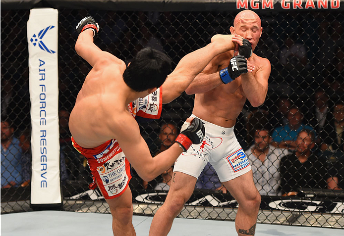 LAS VEGAS, NV - MAY 23:  (L-R) Dong Hyun Kim kicks Josh Burkman in their welterweight bout during the UFC 187 event at the MGM Grand Garden Arena on May 23, 2015 in Las Vegas, Nevada.  (Photo by Josh Hedges/Zuffa LLC/Zuffa LLC via Getty Images)