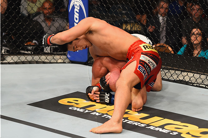 LAS VEGAS, NV - MAY 23:  Dong Hyun Kim (top) punches Josh Burkman in their welterweight bout during the UFC 187 event at the MGM Grand Garden Arena on May 23, 2015 in Las Vegas, Nevada.  (Photo by Josh Hedges/Zuffa LLC/Zuffa LLC via Getty Images)