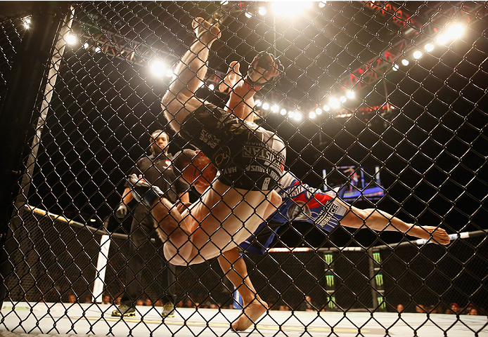 LAS VEGAS, NV - MAY 23: John Dodson (blue shorts) takes down Zach Makovsky in their flyweight bout during the UFC 187 event at the MGM Grand Garden Arena on May 23, 2015 in Las Vegas, Nevada. (Photo by Christian Petersen/Zuffa LLC/Zuffa LLC via Getty Im