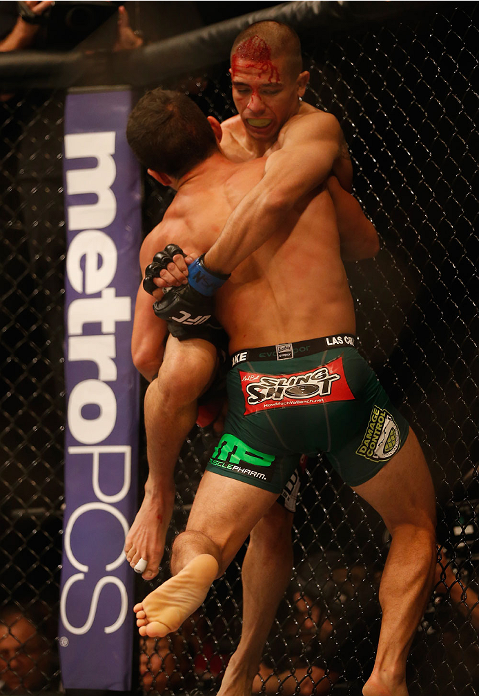 LAS VEGAS, NV - MAY 23:  Joseph Benavidez (green shorts) picks up John Moraga in their flyweight bout during the UFC 187 event at the MGM Grand Garden Arena on May 23, 2015 in Las Vegas, Nevada.  (Photo by Christian Petersen/Zuffa LLC/Zuffa LLC via Getty 